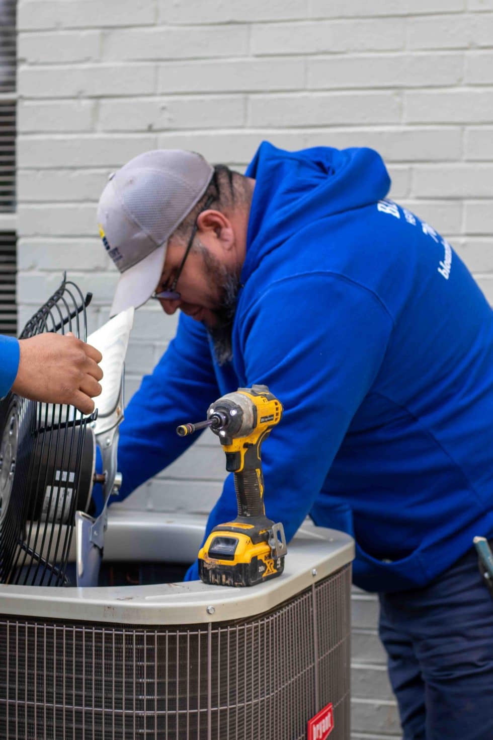 Blount Heating and Cooling technician servicing an outdoor AC unit